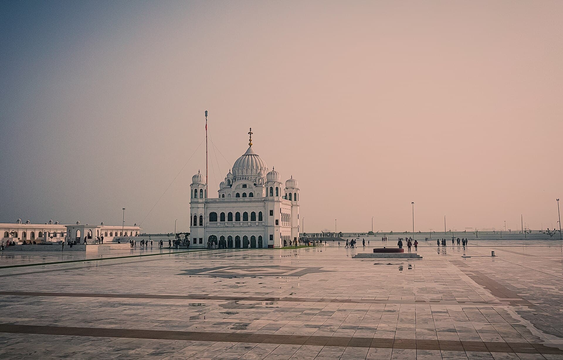 The white domes of Gurdwara Darbar Sahib Kartarpur across its vast marble courtyard at dawn